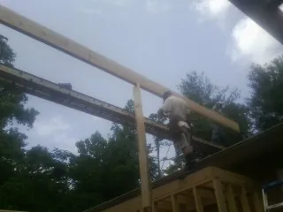 Carpenter setting a ridge beam over a new addition frame — Ice Dam Removal by Roofing Brothers in Essig