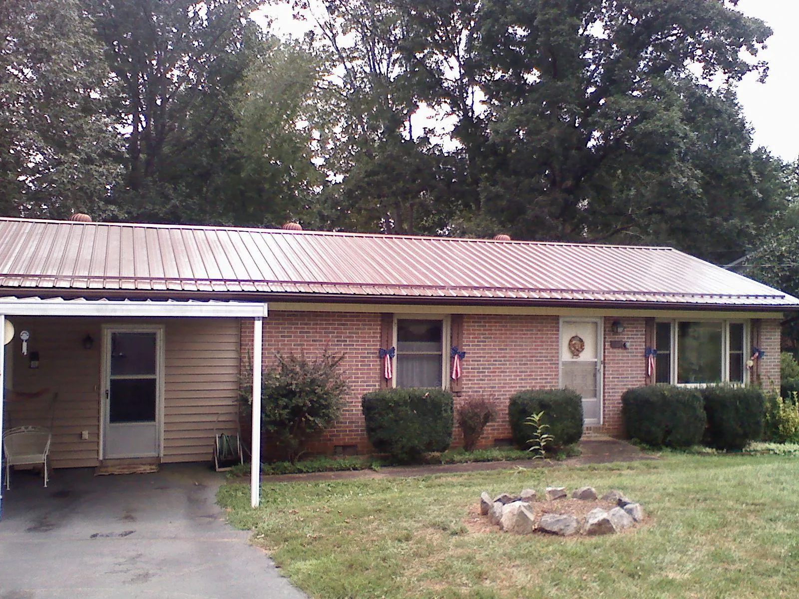 Bronze metal roof and carport on a brick ranch home — Roof Repair work by our crew in Essig